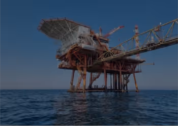 Offshore oil drilling platform standing in the ocean under clear blue sky.